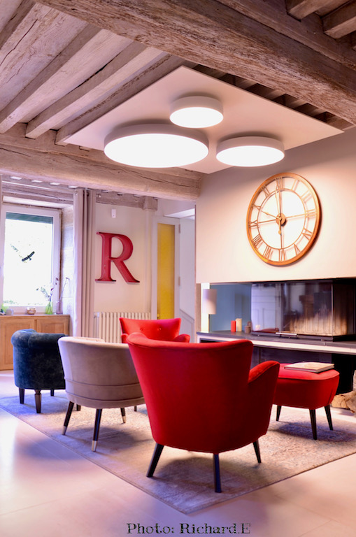 Poutres blanchi salon cheminee contemporain fauteuils rouge velours plafonniers rond hannah elizabeth interior design