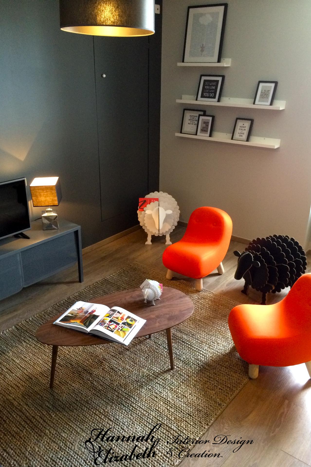 Salon cadres muraux moutons fauteuils orange bob tapis tresse